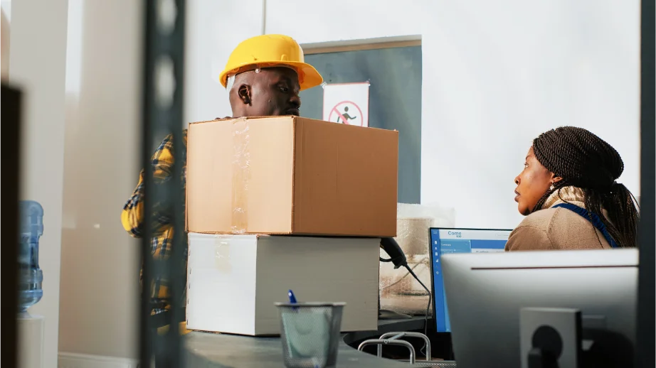 African American employees working with cargo boxes using carton packages from storage room inventory men woman preparing stock distribution shipment quality control